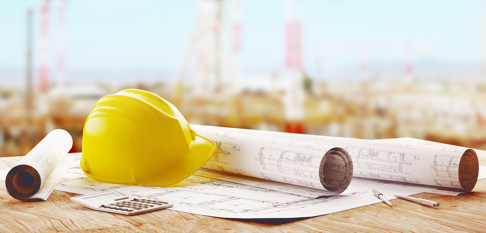 Construction site with a laptop and a smartphone in the foreground.